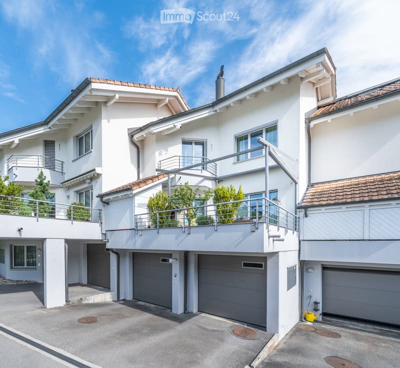 multi-story apartment house, white, with balconies, garage area