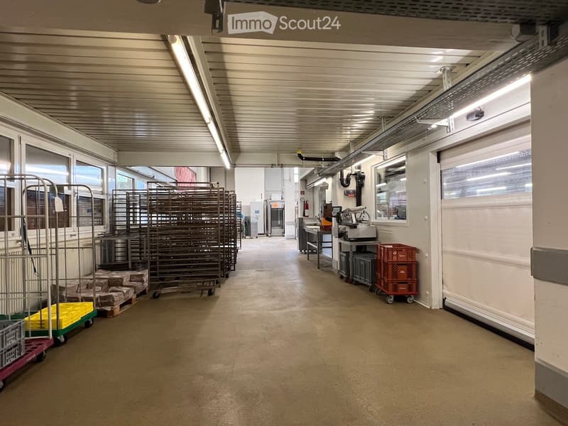 Warehouse with racks, storage boxes, white walls, and ceiling lighting
