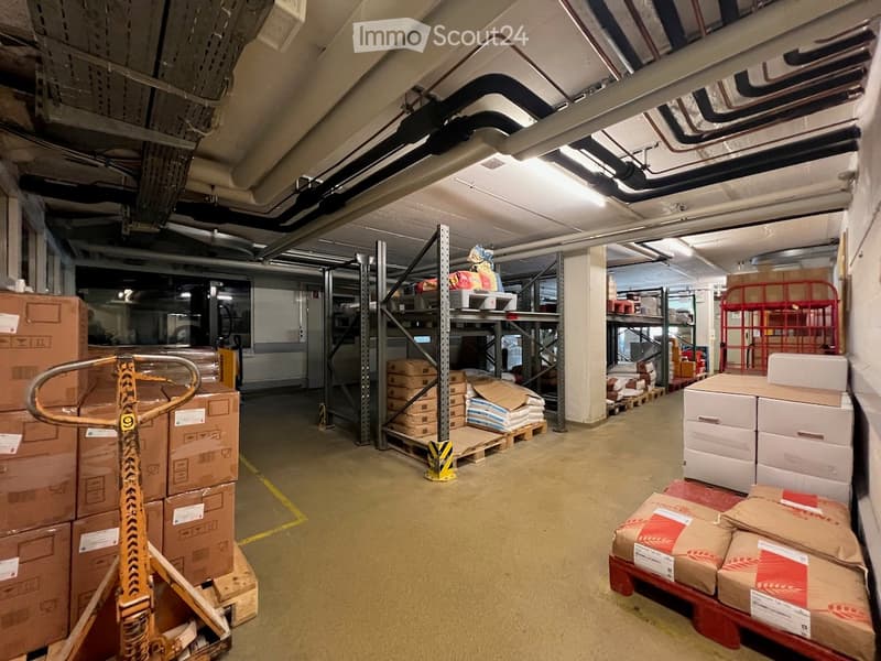 Warehouse: large open space, steel shelves with goods, stacked boxes, forklift, yellow safety lines, overhead pipes, white walls.