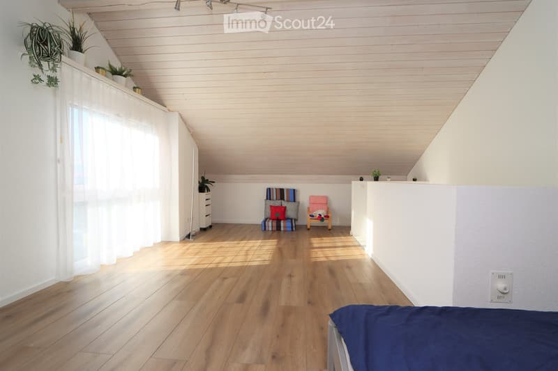 wooden flooring, sloped ceiling, double bed, windows, floor cushions, plants