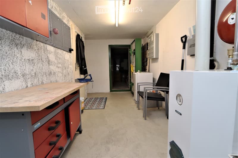 utility room with workshop table, metal cabinets, shelves, fire extinguisher, water cooler