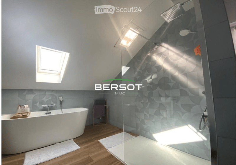 Modern bathroom with a freestanding bathtub, glass-enclosed shower, wooden flooring, and a skylight window providing natural light.
