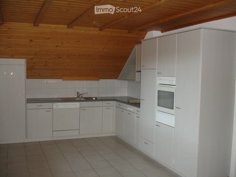 Modern kitchen with white cabinets, stainless steel sink, dishwasher, and oven. Wooden ceiling and tiled floor.