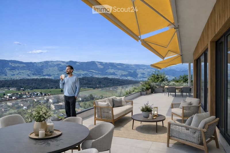 Balcony with a scenic mountain view, furnished with a sofa, chairs, coffee table, and decorative items.