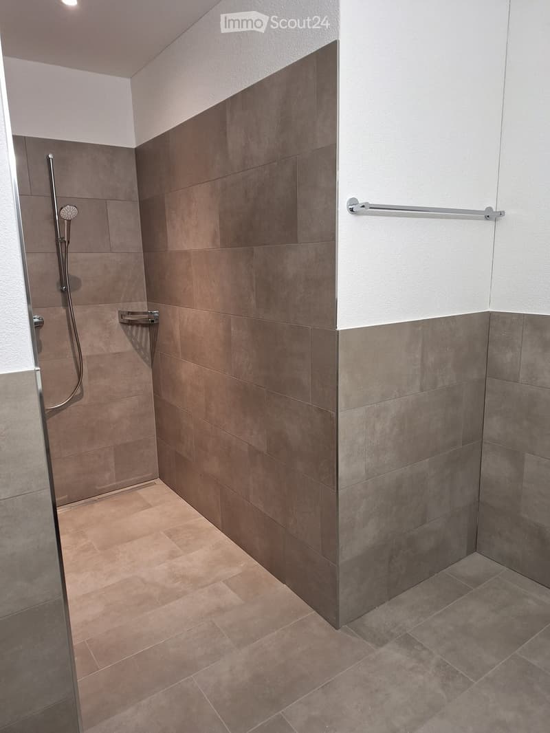 tiled shower, shower head, towel rack, tiled wall