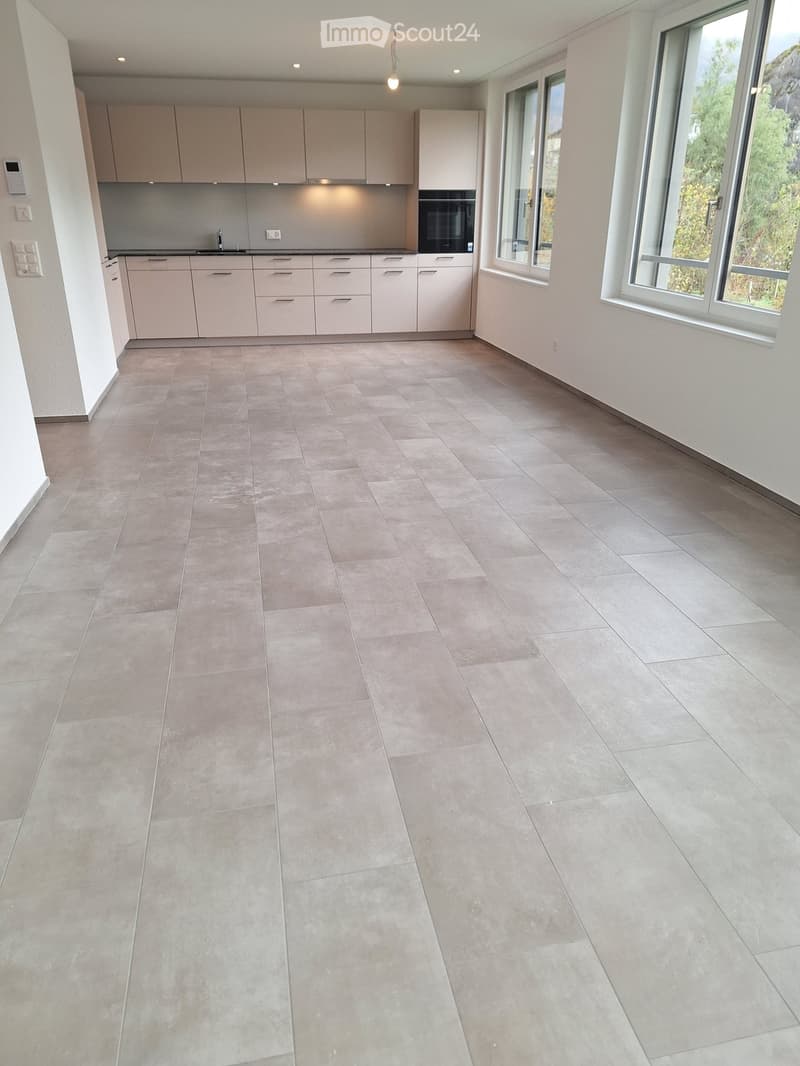 empty kitchen, white cupboards, tiled floor, 2 windows, built-in oven, sink with faucet