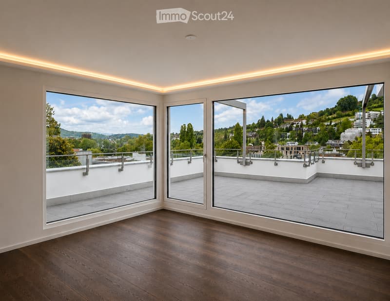 Empty room with wooden flooring, large glass doors opening to a rooftop terrace, and a scenic view of a town and hills.