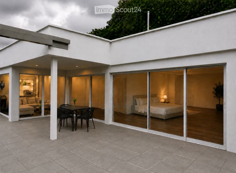 Modern house with large glass sliding doors connecting indoor spaces to an outdoor patio. Visible rooms include a living area with a sofa and a bedroom with a bed.
