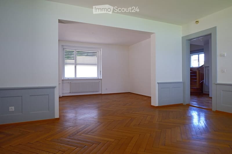 Empty room with wooden flooring, white walls, and a window with blinds. No furniture or equipment present.