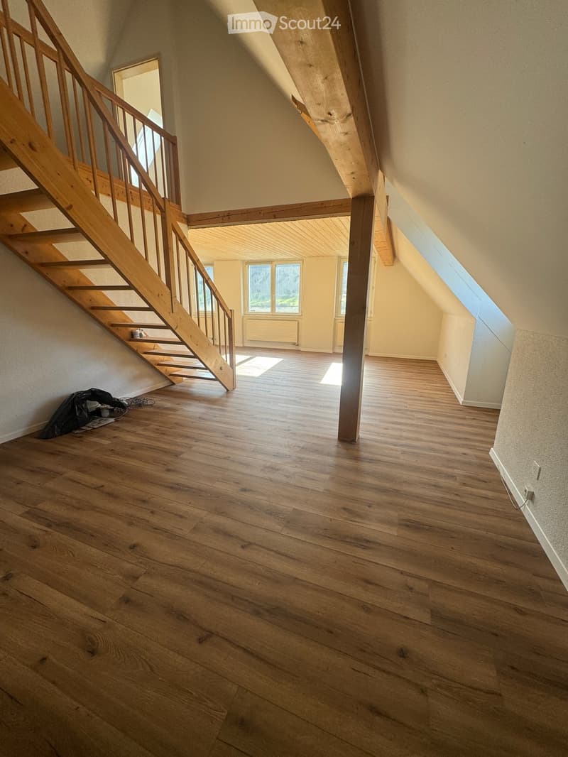 empty attic with wooden stairs, floor, three windows, two skylights