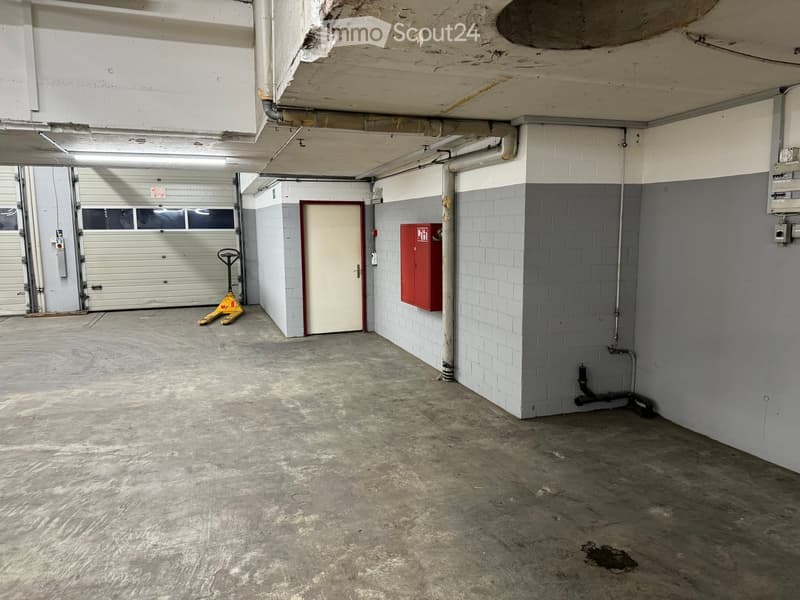 large empty garage with two parking spaces and one closed door