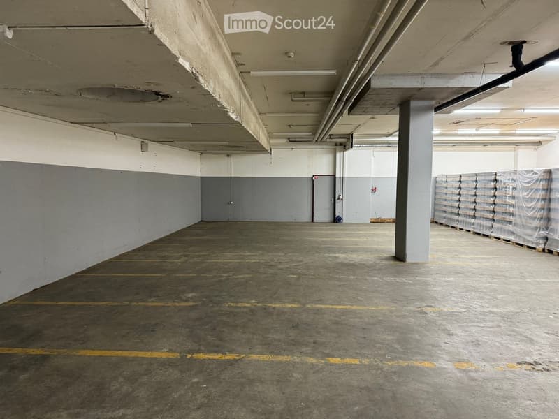 Empty parking lot, gray walls, yellow parking lines, metal beams, open space, no furniture
