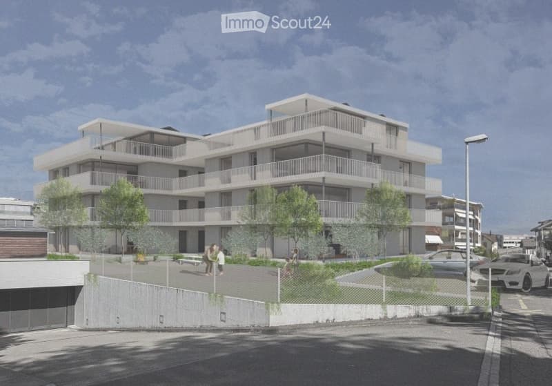 Modern multi-story residential building with balconies, surrounded by trees and a paved area with parked cars.