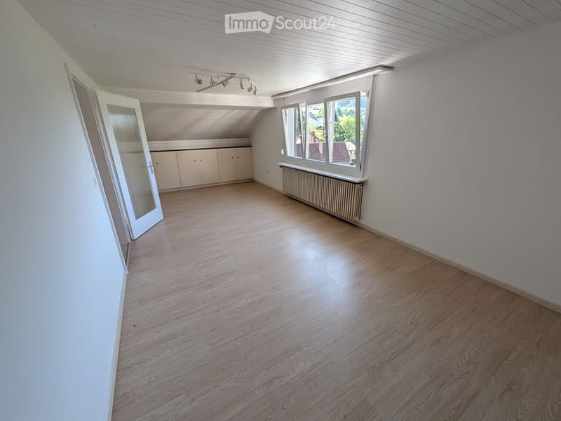 Empty room with wooden flooring, white walls, large windows, and a radiator. No furniture or equipment present.