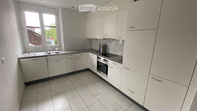 modern kitchen with white cabinets, granite countertops, stainless steel appliances, and a window with a view