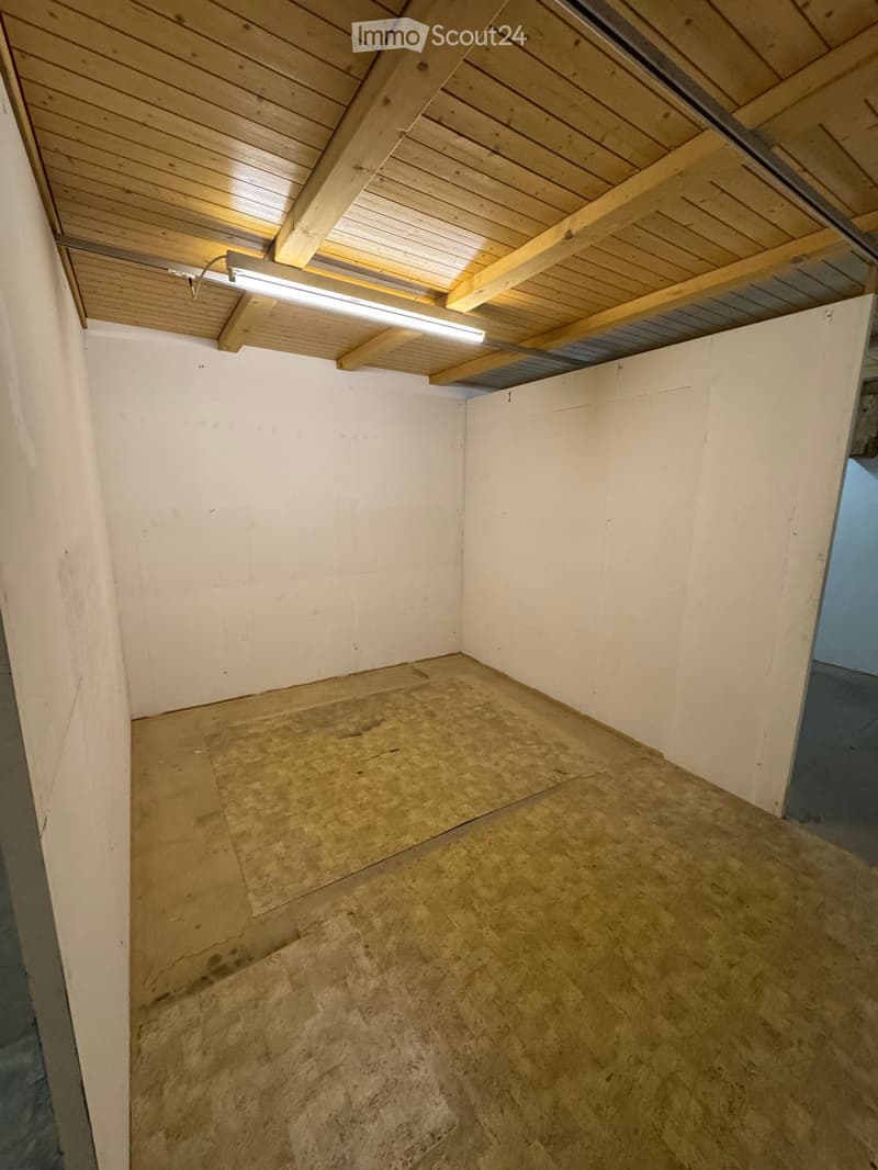 Empty room with white walls, wooden ceiling, and unfinished concrete floor. No furniture or equipment present.