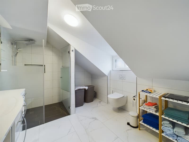 small bathroom with shower, toilet, sink, shelves, and storage bins