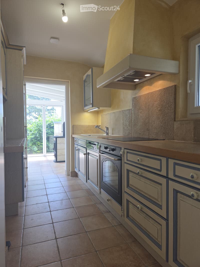 Modern kitchen with light-colored cabinets, a large window, and a sleek sink area.