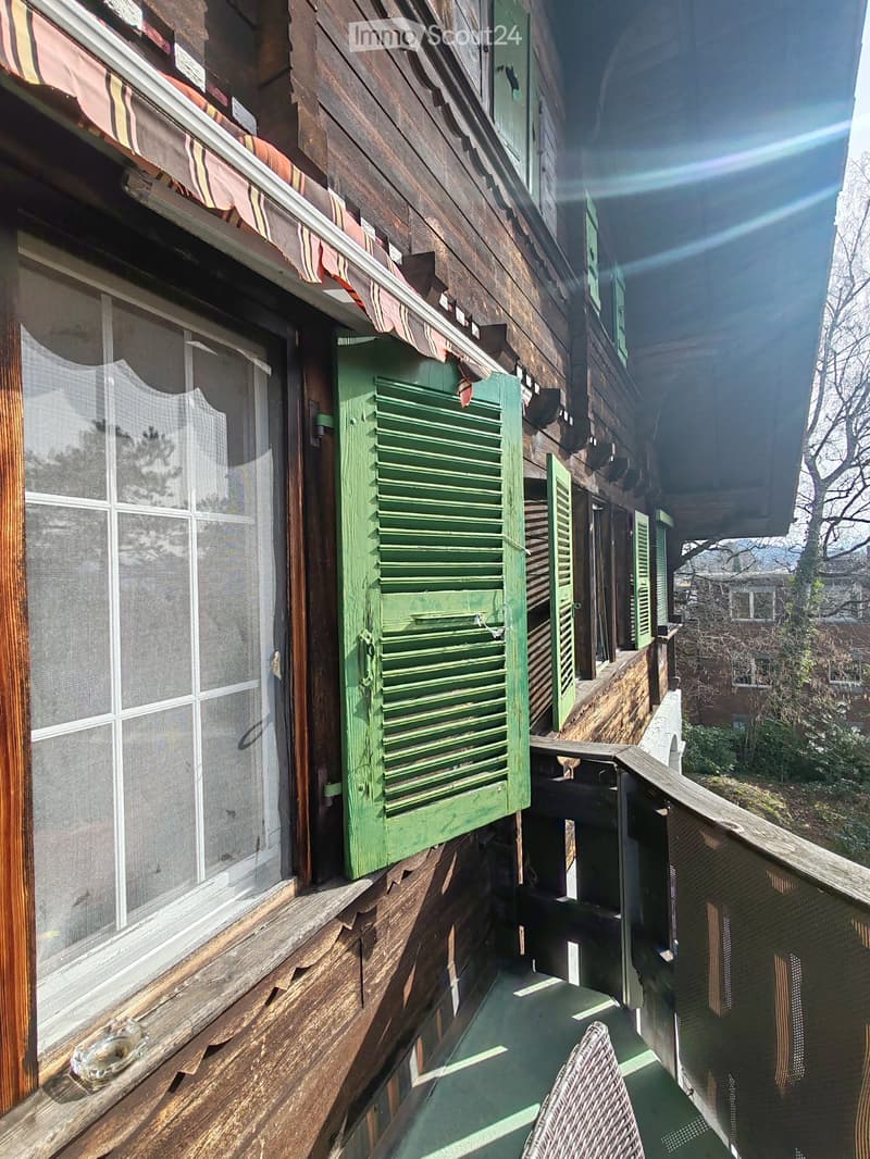 wooden exterior, green shutters, balcony, wooden railing, glass window, wooden floor
