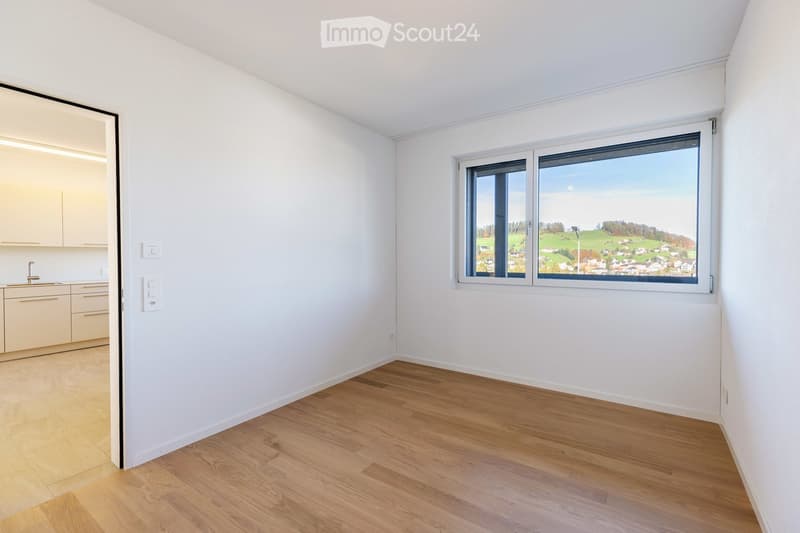 Empty room with large window and view of mountains