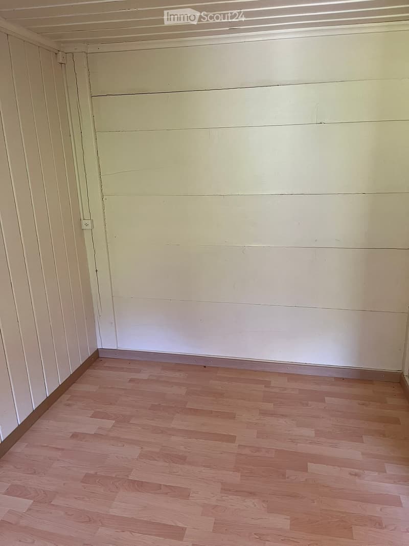 Empty room with light-colored wooden flooring and white walls. No furniture or equipment is present.