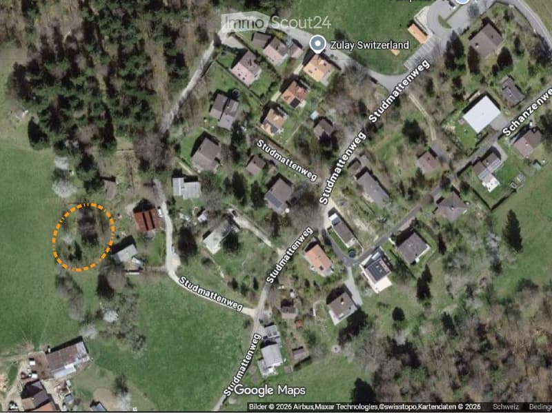 Aerial view of a residential area with multiple houses, roads, and green spaces.