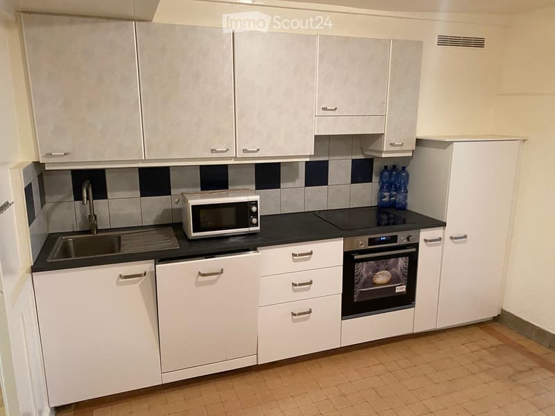 white cabinets, black countertop, stainless steel sink, microwave, oven, dishwasher, faucet