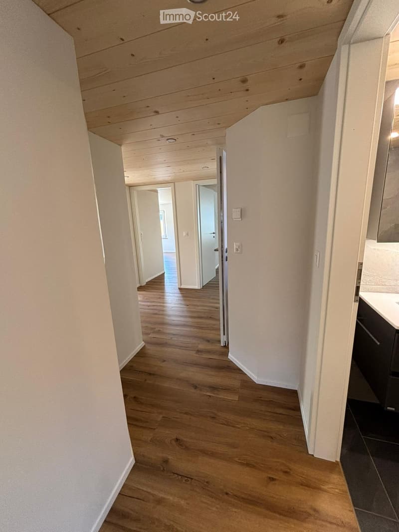 Wooden floors, white walls, wooden ceiling, power outlets, doors to other rooms