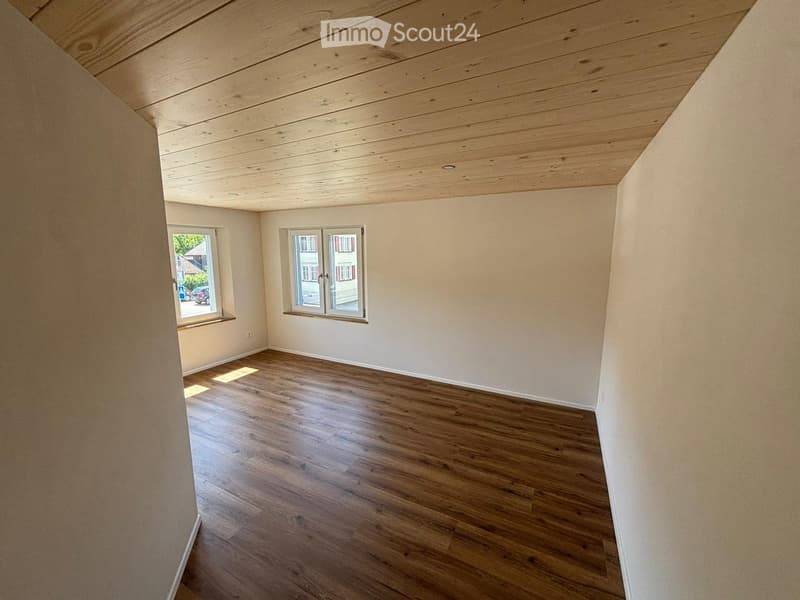 empty room, hardwood floor, white walls, two windows, wooden ceiling