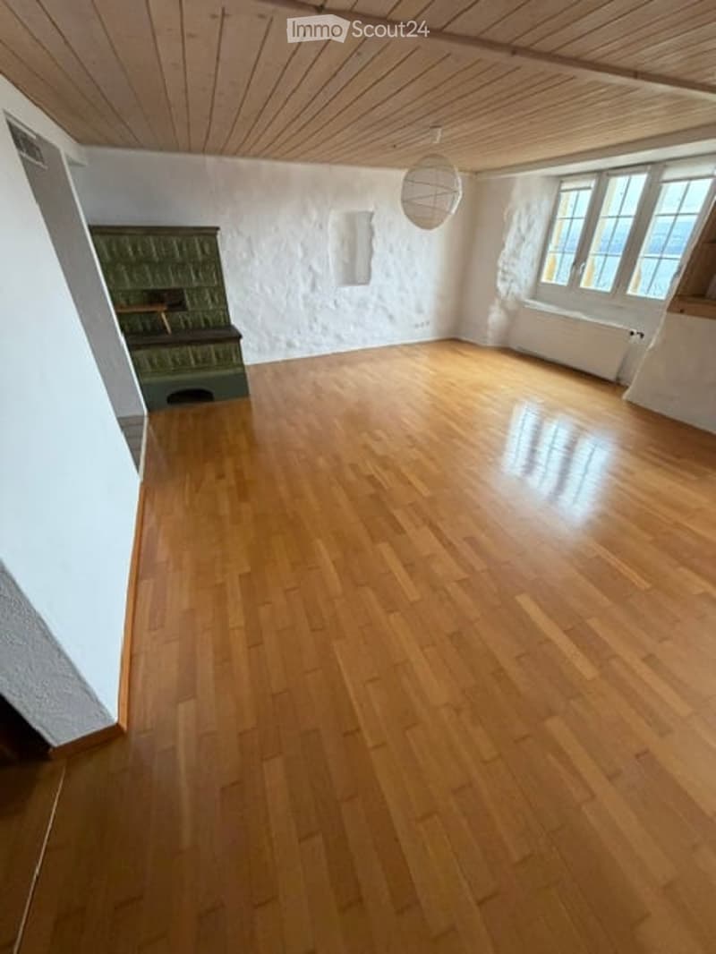 Empty room with wooden flooring, white walls, and a green cabinet in the corner. No furniture or equipment present.