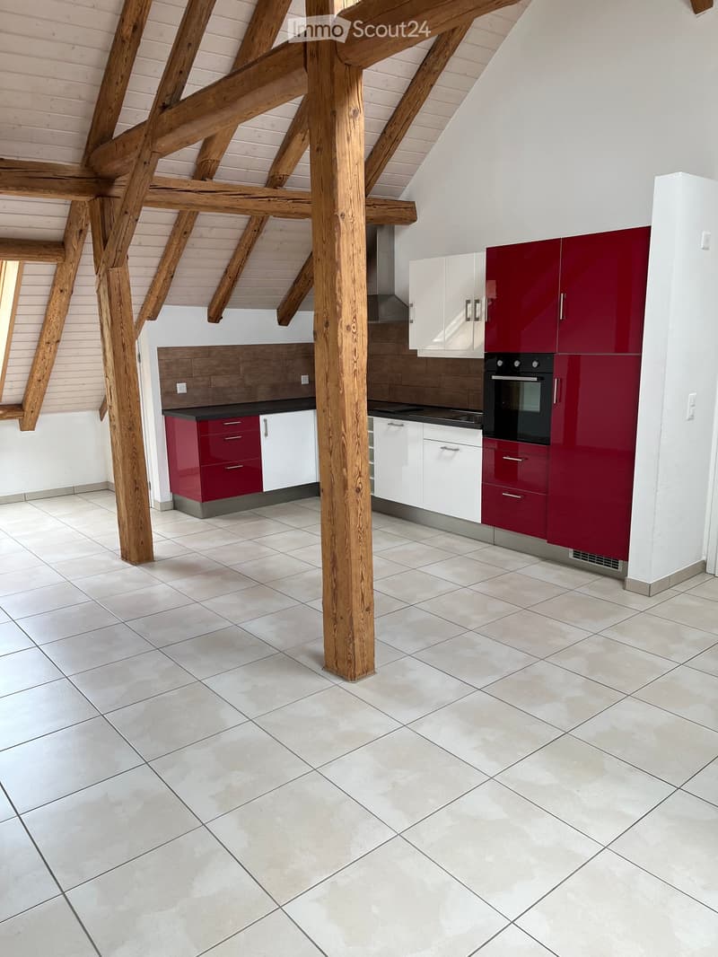 Modern kitchen with white and red cabinets, a central island, and exposed wooden beams on the ceiling.
