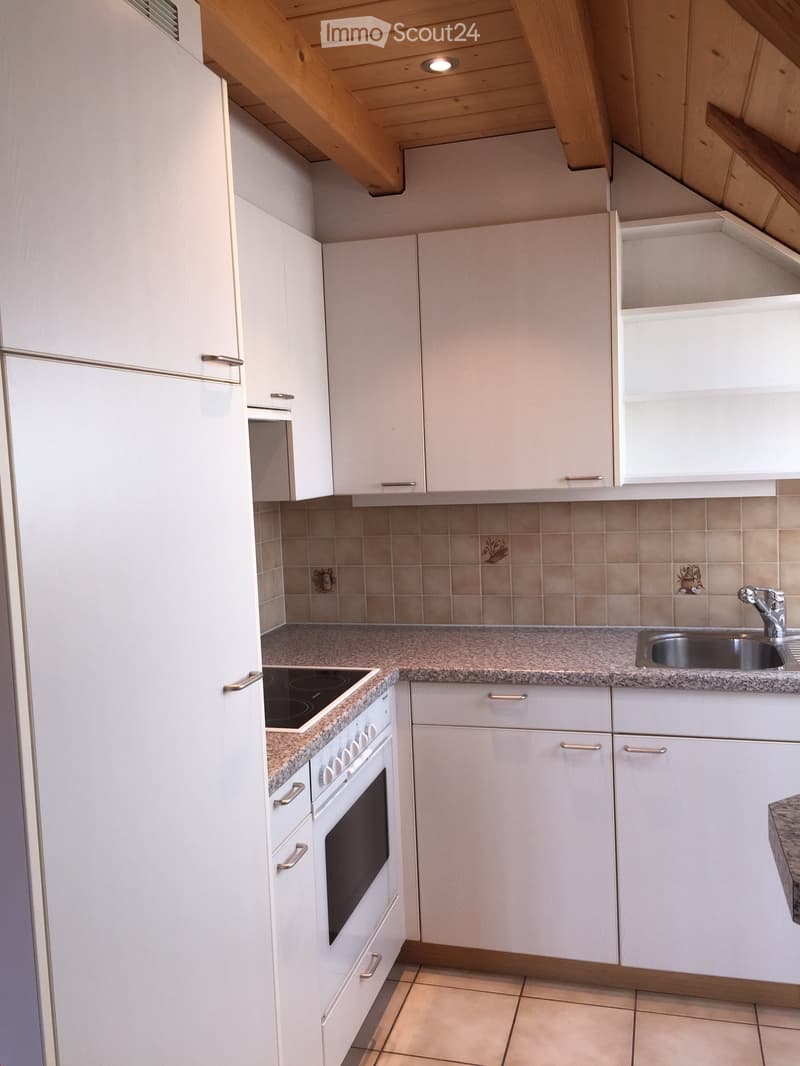 Modern kitchen with white cabinets, granite countertops, stainless steel sink, and built-in appliances including a refrigerator and oven.