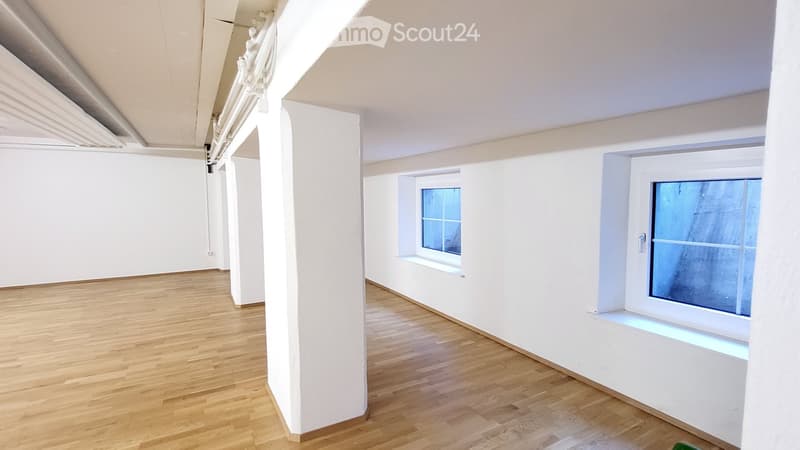 Empty room with white walls, wooden floor, and two windows. No furniture or equipment present.