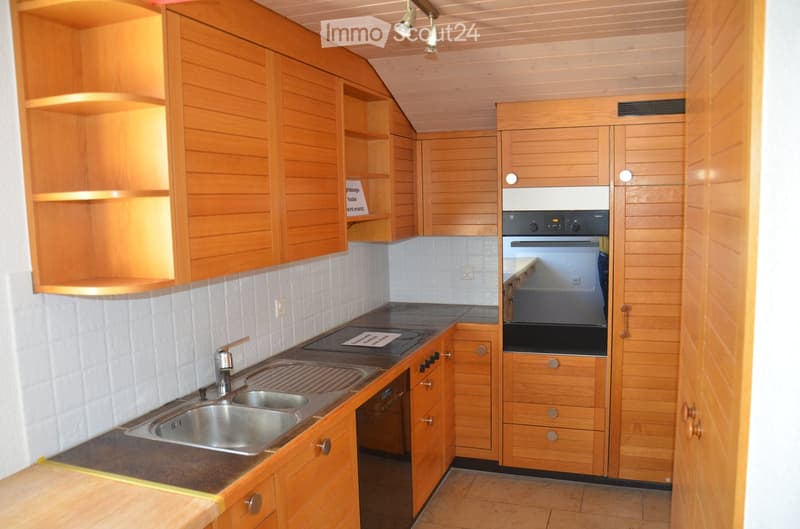 Modern kitchen with wooden cabinets, stainless steel sink, and built-in oven. The space features a clean, organized layout with ample storage and a sleek design.