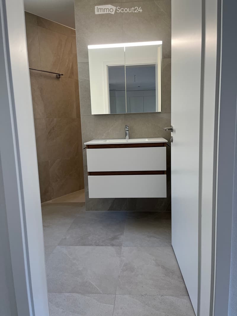 Bathroom with white vanity, mirror, and tiled floor