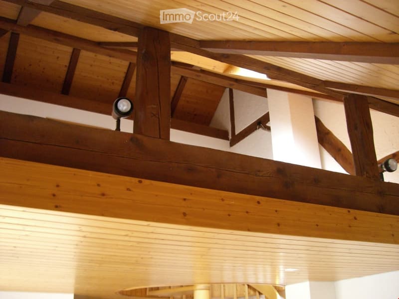 Wooden ceiling with exposed beams and integrated lighting fixtures, creating a warm and inviting atmosphere.