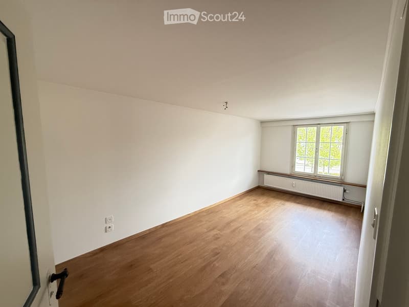 Empty room with wooden flooring, white walls, and a window with a radiator below it. No furniture or equipment is present.