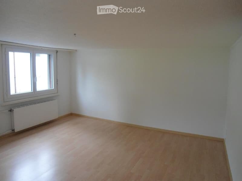 Empty room with wooden flooring, white walls, and a window with white frames. No furniture or equipment present.