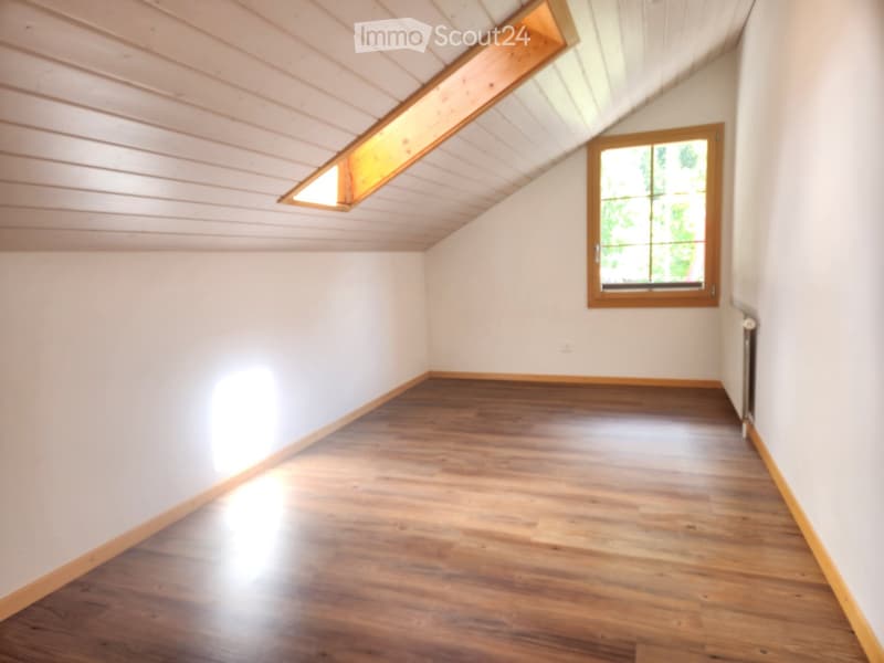 Empty room with wooden flooring, white walls, and a skylight window. No furniture or equipment present.