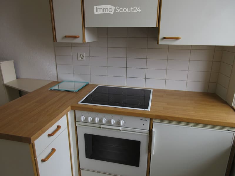 modern fitted kitchen with white cabinetry, wooden countertops, gas stove with oven, dishwasher, electrical outlet on wall