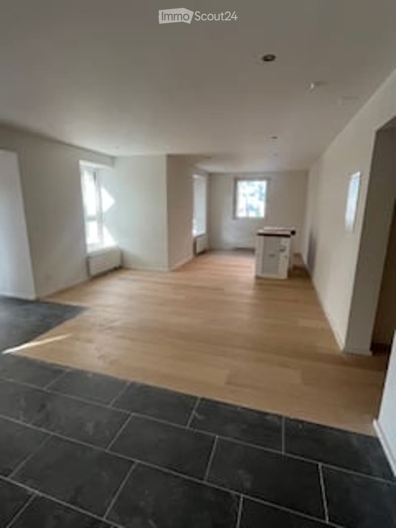 Empty room with wooden flooring and large windows, no furniture or equipment.