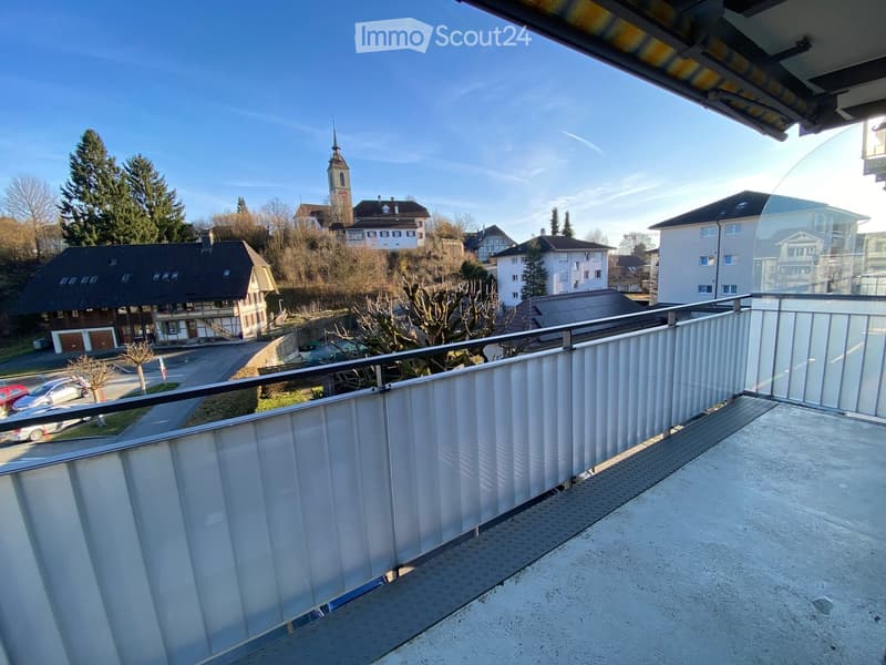 glass railing balcony, town in background, steeple in background, road in background