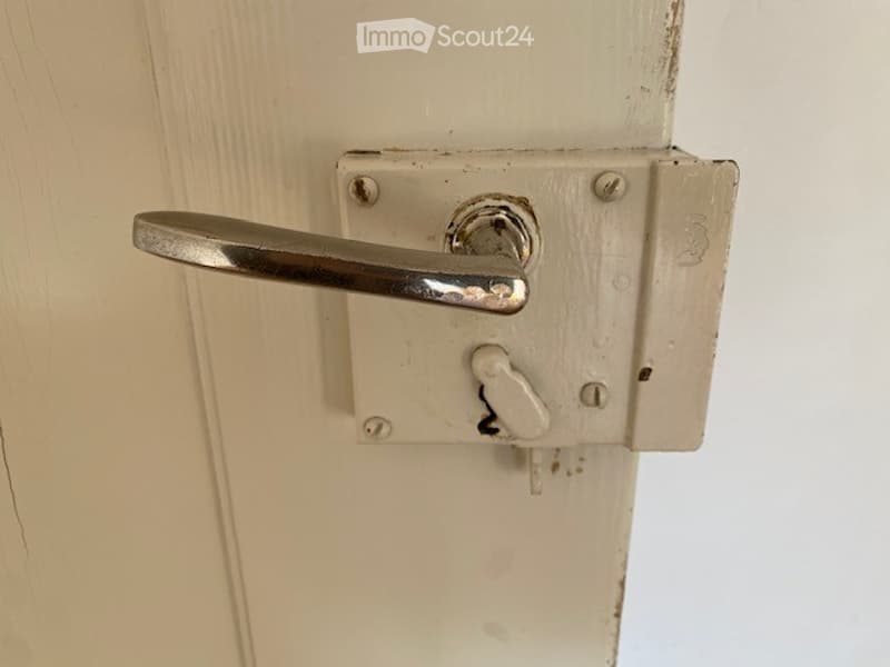 white painted door with metal handle, keyhole, screws