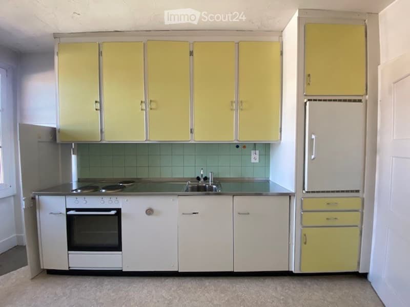 yellow cabinets, green backsplash, stainless steel countertops, double oven, double sink, refrigerator