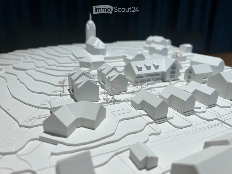 3D model of a small town with multiple houses, pathways, and a central tower-like structure.