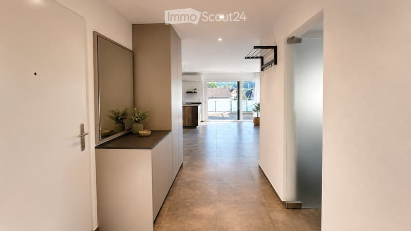 Modern hallway with tiled flooring, white walls, and built-in storage. Features a small console table with decorative items and a coat rack.