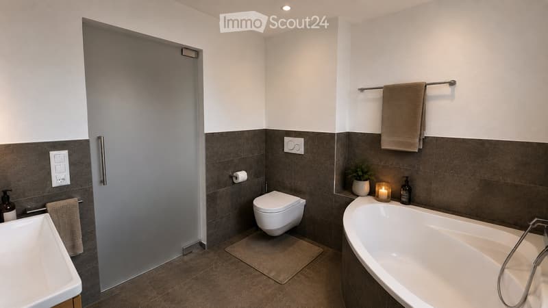 Modern bathroom with a bathtub, toilet, sink, towel rack, and decorative candle on the edge of the tub.