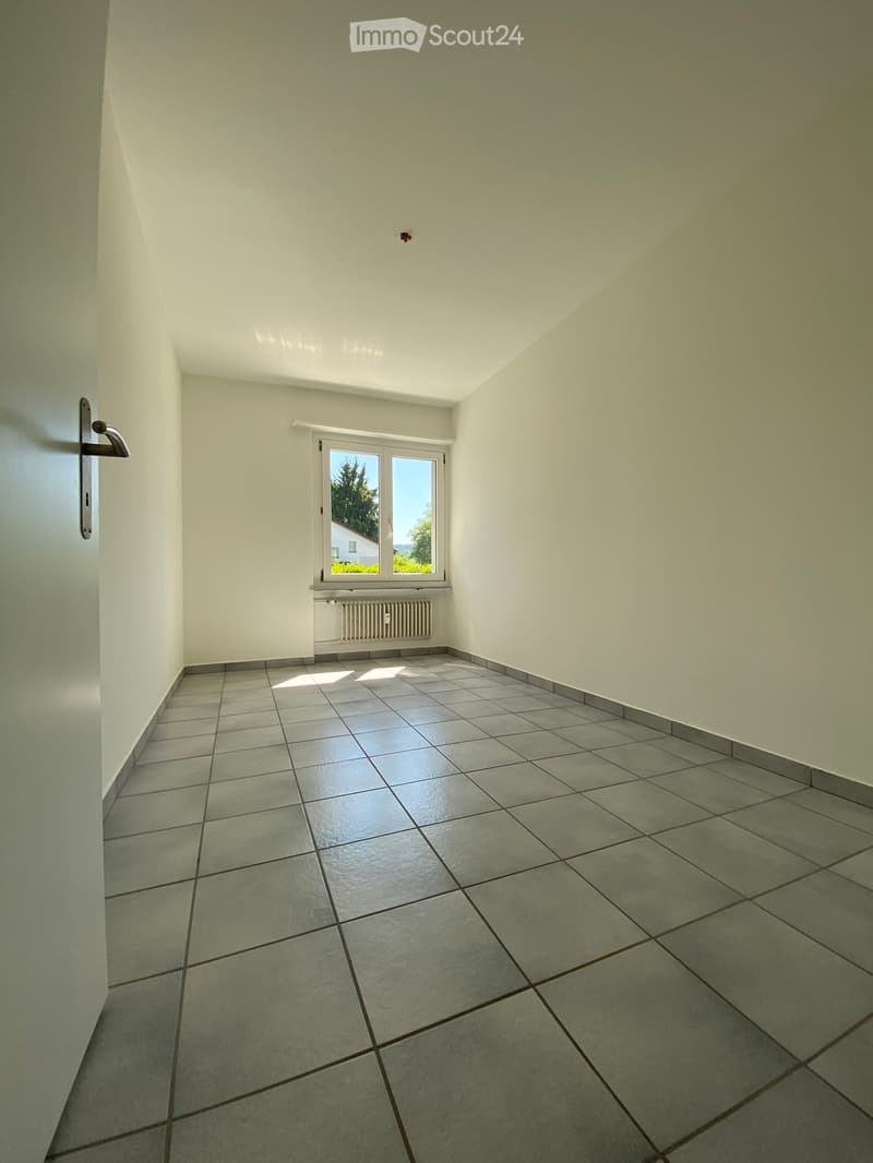 empty room with white walls, tiled floor, window, heater