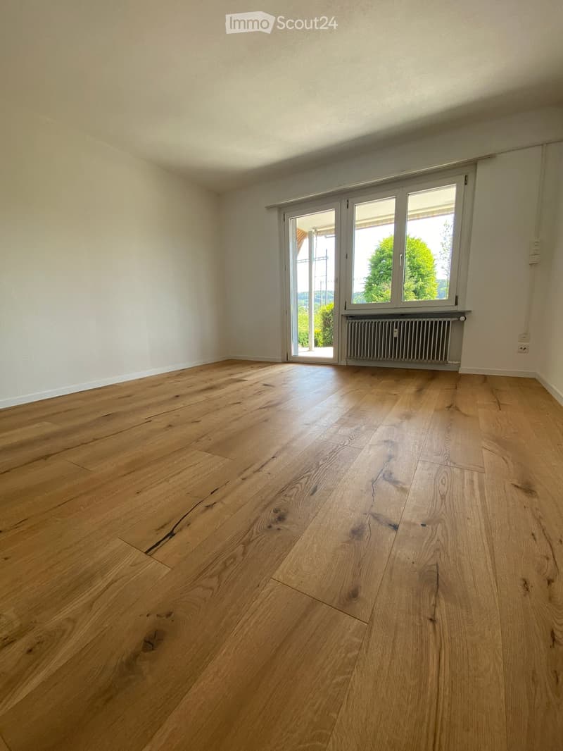 hardwood flooring, sliding glass door, white walls, balcony, heating
