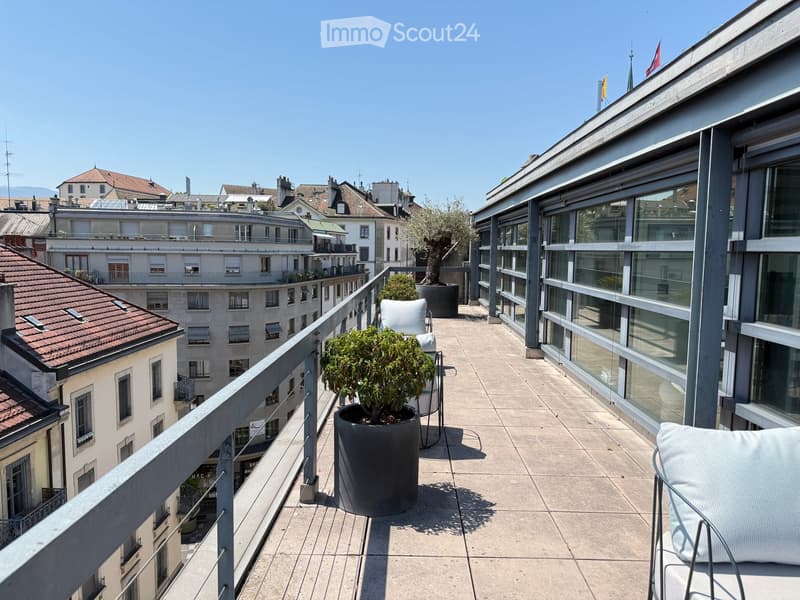 Balcony with modern furniture, potted plants, and a view of the cityscape.